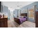 This main bedroom boasts soothing blue walls, wood floors, a ceiling fan and natural light from two windows at 3725 Grand Forks Dr, Land O Lakes, FL 34639