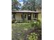 Inviting brick home featuring a covered front porch with columns and well-maintained landscaping at 4106 Old Mulberry Rd, Plant City, FL 33567