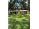 Charming brick home boasts a lush, green lawn and mature trees, complete with a metal roof at 4106 Old Mulberry Rd, Plant City, FL 33567