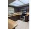 Kitchen with updated stainless steel appliances, wood cabinets, and a tile floor, perfect for modern living at 4106 Old Mulberry Rd, Plant City, FL 33567