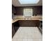 Well-lit kitchen featuring dark wood cabinets, modern appliances, and tile flooring for a functional cooking space at 4106 Old Mulberry Rd, Plant City, FL 33567