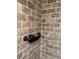 The brick-tiled shower is equipped with a black shower caddy and shower head at 4106 Old Mulberry Rd, Plant City, FL 33567