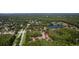 Aerial view of a community with townhomes nestled among lush trees and serene lakes at 4117 Daventry Ln, Palm Harbor, FL 34685