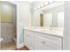 Bathroom featuring a double sink vanity with white cabinets, granite countertops, and a tiled shower at 4117 Daventry Ln, Palm Harbor, FL 34685