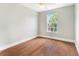 Bright bedroom featuring hard wood floors, a fan, and a window with backyard view at 4117 Daventry Ln, Palm Harbor, FL 34685