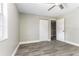 A well-lit bedroom features gray walls, wood-look floors, a closet, and a ceiling fan at 4117 Daventry Ln, Palm Harbor, FL 34685
