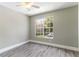 Bedroom with neutral paint, ceiling fan, wood-look flooring, and a large window at 4117 Daventry Ln, Palm Harbor, FL 34685