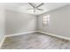 Bedroom with neutral paint, ceiling fan, wood-look flooring, and window at 4117 Daventry Ln, Palm Harbor, FL 34685