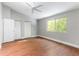 A bedroom with hardwood floor, white trim, window, ceiling fan and closet offers modern comfort and style at 4117 Daventry Ln, Palm Harbor, FL 34685