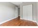 Bright bedroom featuring wood floors, neutral paint, and double door closet at 4117 Daventry Ln, Palm Harbor, FL 34685