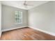 Bright bedroom featuring hard wood floors, a fan, and a window with backyard view at 4117 Daventry Ln, Palm Harbor, FL 34685