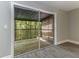 Bedroom with light gray walls, wood-look floors, sliding glass doors and screened-in patio with forest view at 4117 Daventry Ln, Palm Harbor, FL 34685