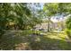 Lush green common area with picnic tables under mature shade trees, surrounded by multi-story townhomes at 4117 Daventry Ln, Palm Harbor, FL 34685