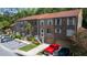 A multi-unit townhome complex showcases its brick facade, red roof, parking, and surrounding trees at 4117 Daventry Ln, Palm Harbor, FL 34685