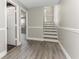 Hallway with wood-look vinyl flooring, decorative trim, and doorway to the staircase at 4117 Daventry Ln, Palm Harbor, FL 34685