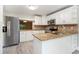 Kitchen with stainless steel appliances, white cabinets, granite countertops, and peninsula with sink at 4117 Daventry Ln, Palm Harbor, FL 34685