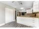 Updated kitchen with white cabinets, granite countertops, stainless steel refrigerator and light grey vinyl flooring at 4117 Daventry Ln, Palm Harbor, FL 34685