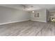 Spacious living room with modern gray laminate flooring, natural light, and freshly painted walls at 4117 Daventry Ln, Palm Harbor, FL 34685