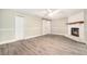 Spacious living room featuring a brick fireplace, wood-look vinyl flooring, and neutral colors at 4117 Daventry Ln, Palm Harbor, FL 34685