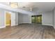 Spacious living room featuring modern flooring, stylish light fixtures, and sliding glass doors leading to a balcony at 4117 Daventry Ln, Palm Harbor, FL 34685