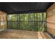 A screened-in patio features bamboo blinds and a wood floor, offering serene views of a lush, green forest at 4117 Daventry Ln, Palm Harbor, FL 34685