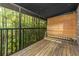 This screened-in patio with wood floors and bamboo blinds offers views of a green forest at 4117 Daventry Ln, Palm Harbor, FL 34685