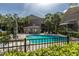 Community pool with lounge chairs and surrounding greenery, palm trees and condo buildings at 4117 Daventry Ln, Palm Harbor, FL 34685
