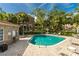 Community pool with lounge chairs and surrounding greenery, and close to a condo building at 4117 Daventry Ln, Palm Harbor, FL 34685