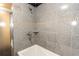Close up of the shower with gray tile surround and jacuzzi tub at 4117 Daventry Ln, Palm Harbor, FL 34685