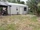 Exterior view of the backyard featuring a detached storage shed with a metal roof and door at 4209 E Hanna Ave, Tampa, FL 33610