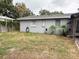 Exterior view of the home's backyard with grass and partial fence and some foliage at 4209 E Hanna Ave, Tampa, FL 33610