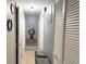 Hallway with tiled floor, doors to rooms, a red accent table with a flower arrangement, and closet space at 4209 E Hanna Ave, Tampa, FL 33610