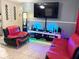 Stylish living room featuring red and black leather chairs, sleek entertainment center with modern lighting and large screen TV at 4209 E Hanna Ave, Tampa, FL 33610