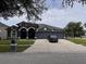 Beautiful single-story home featuring a three-car garage, dark gray exterior, and well-manicured lawn at 4217 Balington Dr, Valrico, FL 33596