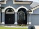 Inviting front entrance with a double door entry, arched transom windows, and a charming porch swing at 4217 Balington Dr, Valrico, FL 33596