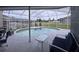 Covered outdoor living space with lounging area and a beautiful swimming pool at 4217 Balington Dr, Valrico, FL 33596