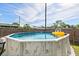 Above-ground pool with a ladder and yellow float in a fenced-in backyard on a sunny day at 5315 40Th N St, St Petersburg, FL 33714