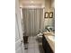 Bathroom featuring a shower with a curtain, granite countertop, and decorative framed art at 5811 White Oak Bayou Ct, Bradenton, FL 34203