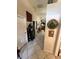 Hallway with neutral walls, tile flooring, and decorative accents leading to other rooms at 5811 White Oak Bayou Ct, Bradenton, FL 34203