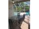 Screened-in patio with table and chairs, adjacent to pool area and green backyard at 5811 White Oak Bayou Ct, Bradenton, FL 34203
