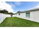 The home's backyard features a well-manicured lawn and white fence at 717 Pinewood Dr, Dunedin, FL 34698