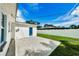 Backyard featuring a cement patio, a small blue door, a white fence, and a lush green lawn at 717 Pinewood Dr, Dunedin, FL 34698
