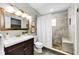 Bathroom featuring a vanity with a wood cabinet, a large mirror, and a tiled shower with a built-in bench at 717 Pinewood Dr, Dunedin, FL 34698