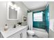 Bathroom featuring blue-green tiles in the bathtub surround, a white vanity, and a neutral color scheme at 717 Pinewood Dr, Dunedin, FL 34698