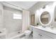 Bathroom featuring white marble-style tile in the shower and flooring, along with a white vanity and decor at 717 Pinewood Dr, Dunedin, FL 34698