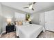 Cozy bedroom with a modern ceiling fan, neutral color palette, soft lighting, and stylish decor at 717 Pinewood Dr, Dunedin, FL 34698