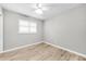 Bedroom featuring hardwood floors, a ceiling fan, and a bright window with white shutters at 717 Pinewood Dr, Dunedin, FL 34698