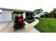Well-maintained home exterior showcasing a lush lawn, a golf cart, and a charming facade at 717 Pinewood Dr, Dunedin, FL 34698