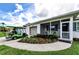 Charming home exterior featuring a well-manicured lawn, lovely landscaping and a golf cart parked in the driveway at 717 Pinewood Dr, Dunedin, FL 34698