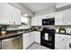 Modern kitchen with white cabinetry, stainless steel appliances, and a functional layout at 717 Pinewood Dr, Dunedin, FL 34698